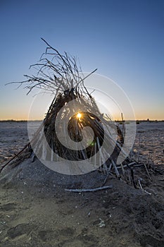 The rays of the setting sun through a straw hut on the shore. Durankulak, Northern Black Sea Coast, Bulgaria.