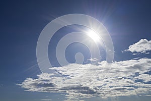 Rays of the sun in the blue sky and white clouds