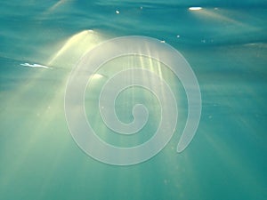 Rays of Sun light shine underwater