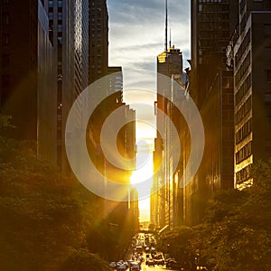 Rays of sunlight shining between the skyline buildings along 42nd Street in Midtown Manhattan, New York City photo
