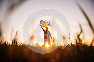 In rays of the sunset sun, bald man with glasses with kite in the field. Father plays with children