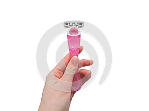 Razor in a female hand on a pink background. Removal of unwanted hair.Women`s Shaving Razor. top view.Concept of using razor.