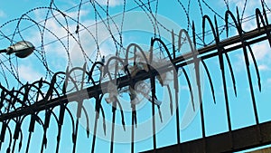 Razor wire. Barbed wire fence with sharp spears. Prison, jail view