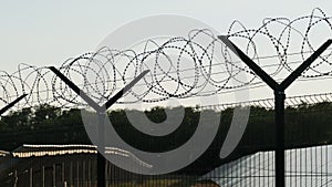 Razor Wire Fence Around the Solar Power Plant During Sunset