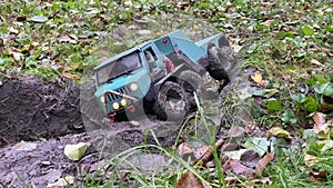 RC toy vehicle passing through trench with wet soil.