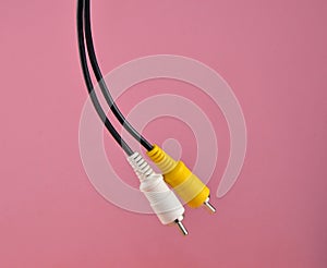 RCA yellow white audiovideo cable on pink background.