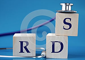 RDS - acronym on wooden large cubes on blue background with stethoscope