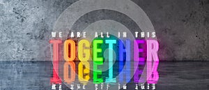 WE`RE ALL IN THIS TOGETHER rainbow-colored text sign on concrete wall 3d render