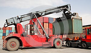 Reach stacker vehicle moving a container into a container terminal area