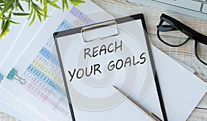 Reach Your Goals. text on white paper on a light background