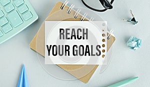 Reach your goals written on a white notebook. Closeup of a personal agenda