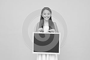 Read this. Something you need to know. Happy smiling girl hold blackboard. Small kid with blank blackboard