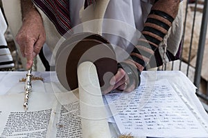 A reader of the Torah uses a yad or pointer as a guide