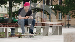 Readhead hipster in with a smartphone in hand