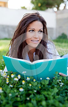 Reading a book lying on the grass