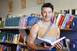 Reading book, portrait or happy man in library at university, college or school campus for education. Bookshelf