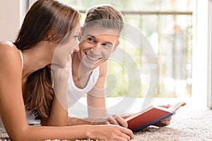 Reading a book together. Handsome young men reading a book to hi