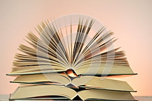 Reading books and literature.Open books stack on a light pink background. Study and education concept. Close-up book