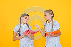 Reading books. Reading and retelling. Small children holding books yellow background. Sincere interest. Little girls photo