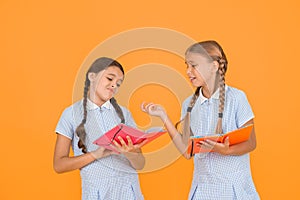 Reading books. Reading and retelling. Small children holding books yellow background. Sincere interest. Little girls photo