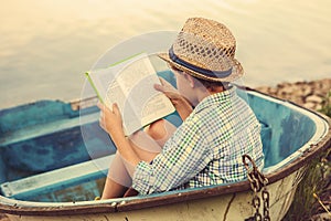 Reading boy in old boat