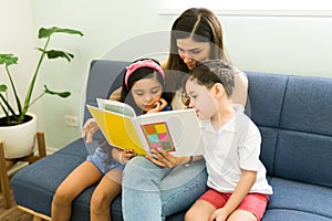 Reading a children`s story for her son and daughter