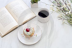 Reading with a cupcake and coffee