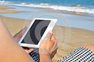 Reading on an e-book on the beach