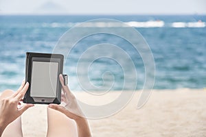 Reading from e-reader on the beach