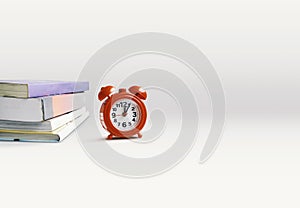 Reading, Education concept. Books stacking with alarm clock on white background with copy space.