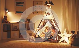 Mother and child daughter reading a book and a flashlight before