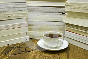 Reading glasses with cup of tea and books