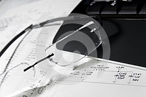 Reading glasses, keyboard and engineering drawing