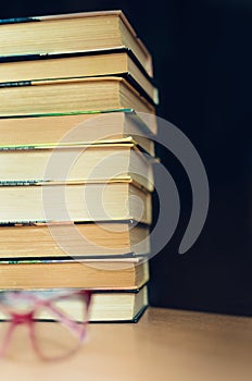 Reading glasses next to a stack of books