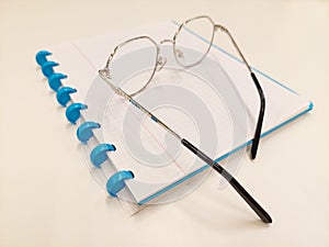 Reading glasses on open booklet with white background