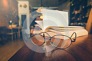 Reading glasses on table with open book