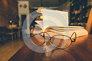 Reading glasses on table with open book