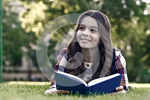 Reading helps your seed of knowledge grow. Happy kid read book lying on green grass. Knowledge day. September 1. Back to