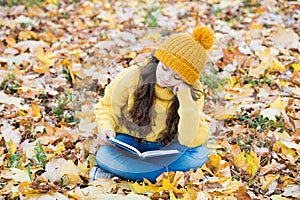 Reading really matters. Little child read book sitting on fall leaves. School library. Knowledge and informaiton