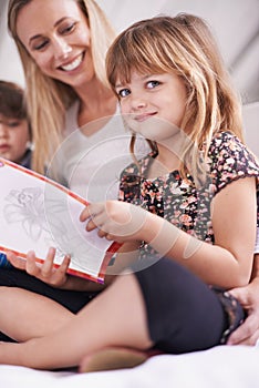 Reading, mom and daughter on sofa with book for bonding, teaching and learning together in home. Story, mother and child