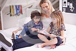 Reading with mom. Shot of a mother reading with her children at home.