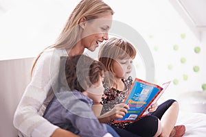 Reading, mother and children on sofa with story for bonding, teaching and learning together in home. Woman, son and