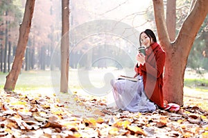 Reading in nature is my hobby,Girl with book and tea in the autumn park