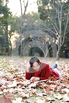 Reading in nature is my hobby, girl Read book lying On full of maple leaves