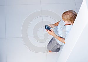 Reading and sending text message. Top view of young business woman reading text message - copyspace.