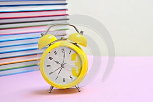 Reading time. Children`s books and an alarm clock. School knowledge.