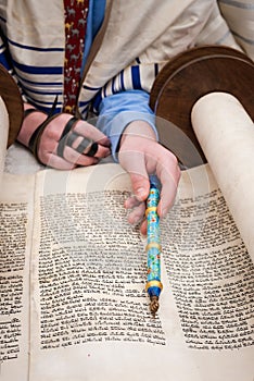 Reading from the Torah scroll using a silver pointer or yad