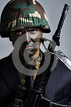 Ready for a battle. A young military man wearing camouflage facepaint.