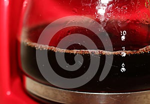 Ready coffee in a glass jar, prepared by a coffee machine. It`s useful to keep coffee warm