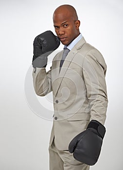 Ready for the corporate fight. Portrait of a handsome african businessman wearing boxing gloves.